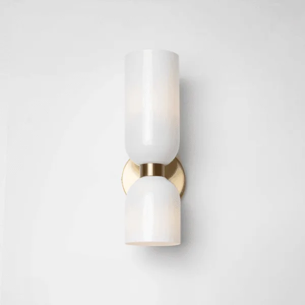 Front view of the opal borosilicate glass wall sconce for bedroom: tall cylinder above a dome on a satin brass finish backplate