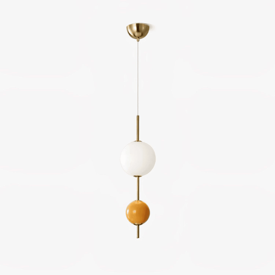 Glass ball pendant light in gold with a white opal globe above an orange glass ball on a brass stem