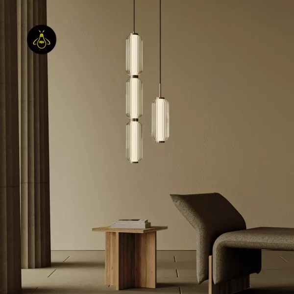 Large three-barrel and small cylinder pendant light hanging in a living room over a wooden side table