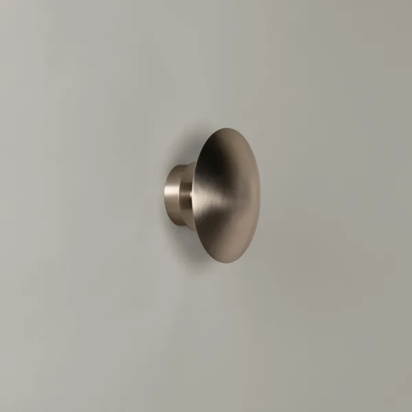 LED wall light in satin nickel, 304 stainless steel dome disc on a grey wall, side view, switched off