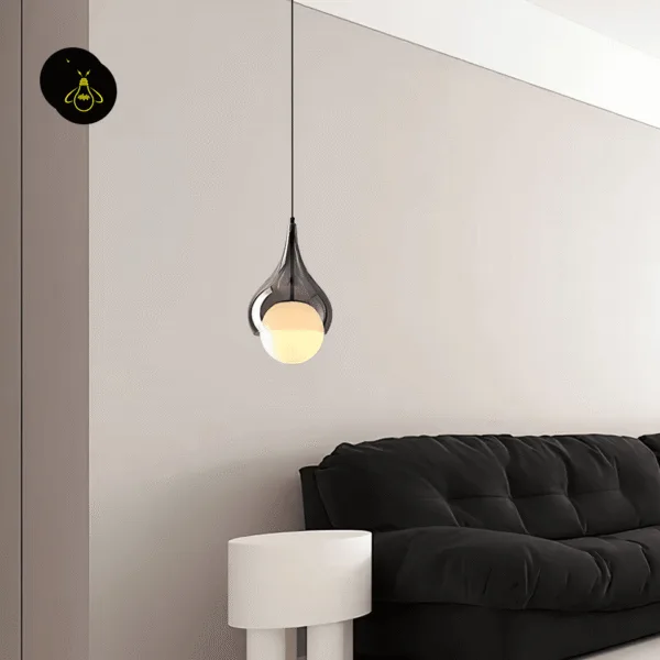 Hanging bedside light in smoked glass, lit beside a black sofa and a white side table