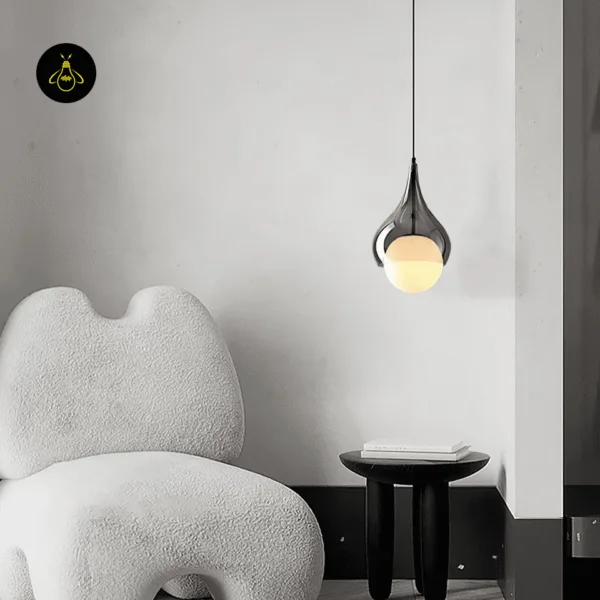 Hanging bedside light in smoked borosilicate glass over a small side table beside a lounge chair