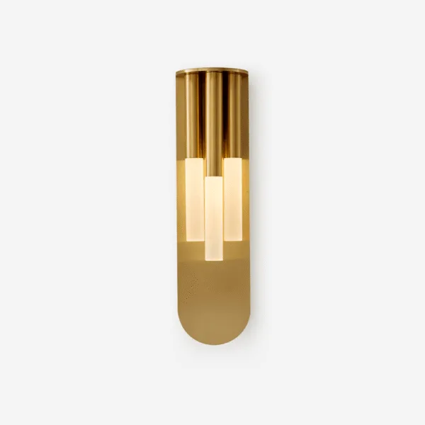 Glass wall lamp with three opal borosilicate glass tubes on a gold stainless steel backplate, lit, on a plain background