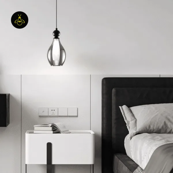 Black smoked glass pendant light hanging beside a bed as a bedside light