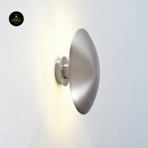 Round LED wall light in a living room, satin nickel disc with a soft halo glow