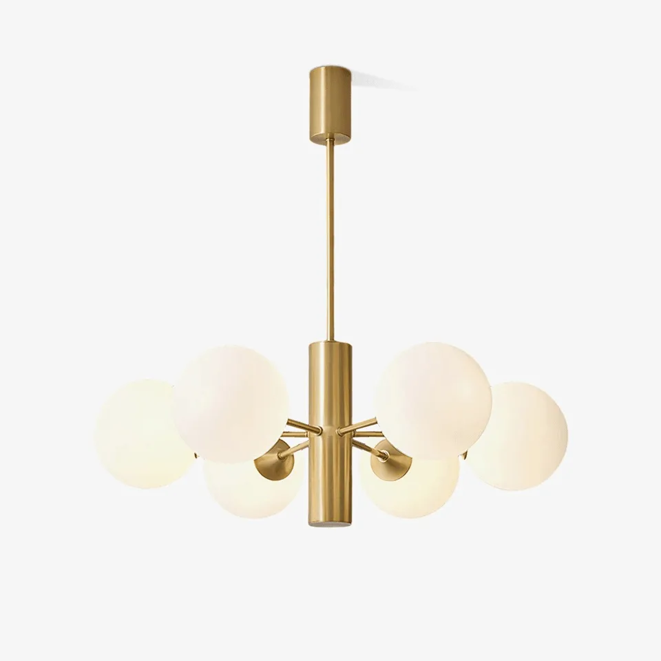 Modern brass chandelier with 8 opal glass globes hanging over a dining table