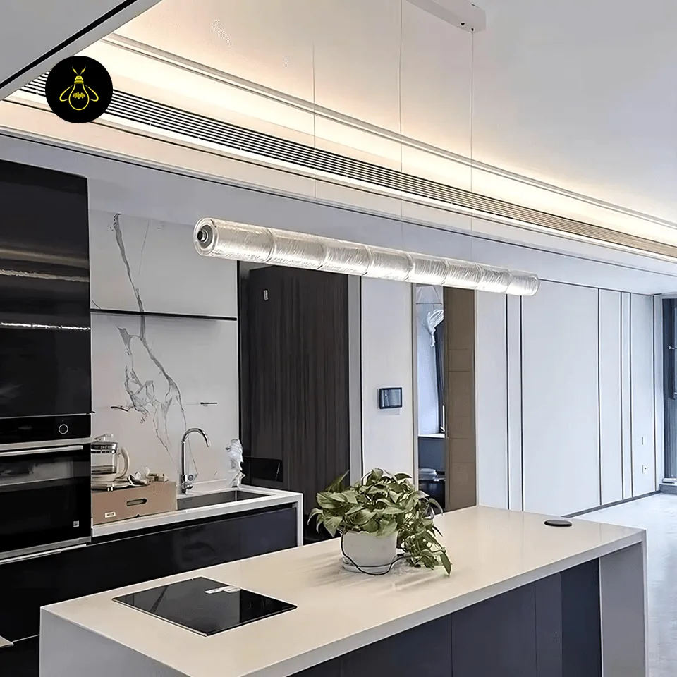 Linear segmented glass chandelier lighting a modern kitchen island with a warm LED glow