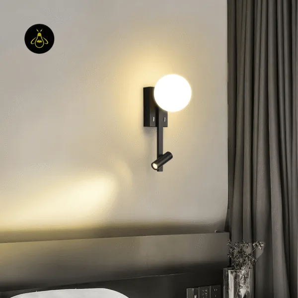 Wall mounted study lamp above a bed, opal globe glowing and the reading spot casting a warm beam on the wall