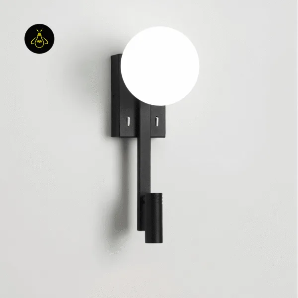 Wall mounted study lamp on a pale grey wall, opal globe glowing, with two switches on the matte black backplate