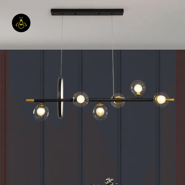 Linear dining chandelier with six clear borosilicate glass globes above a kitchen island