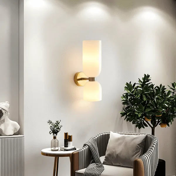 Wall sconce for bedroom or living room glowing up and down above a striped armchair and side table