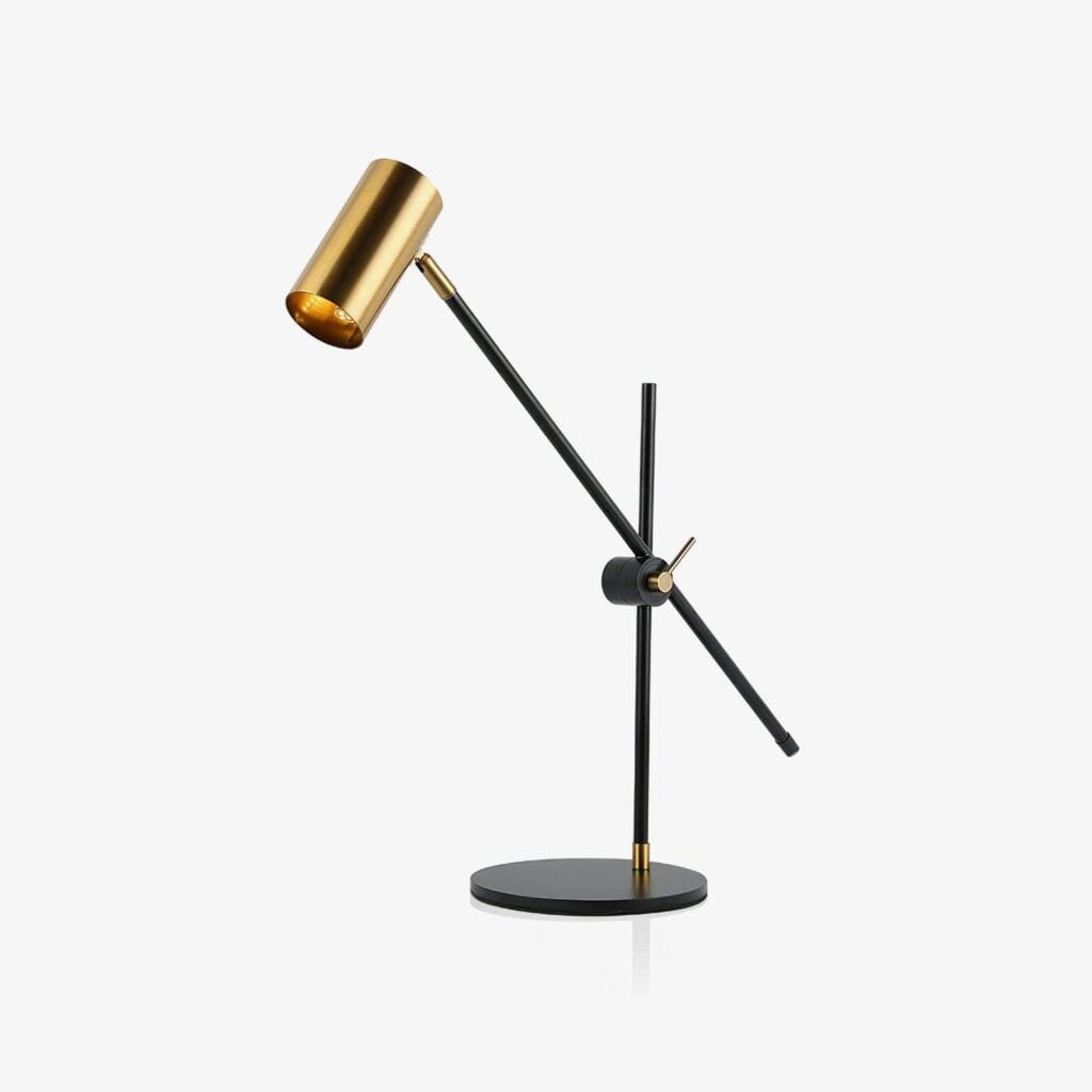 Brass desk lamp with adjustable black balance arm and gold spot head on a round base