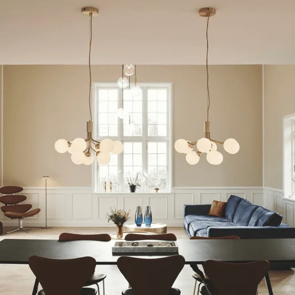 Glass globe cluster chandelier lit warm-white over a dining and living space