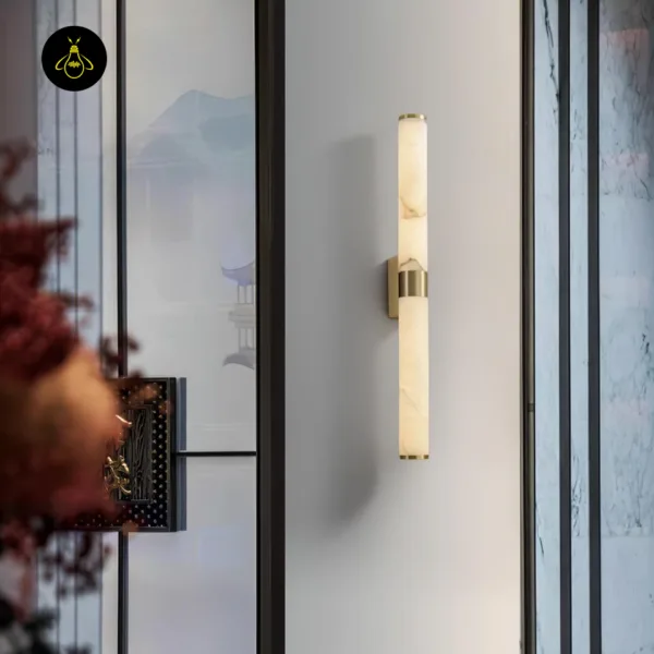 Alabaster wall light glowing on a white wall beside a glass partition in a hallway