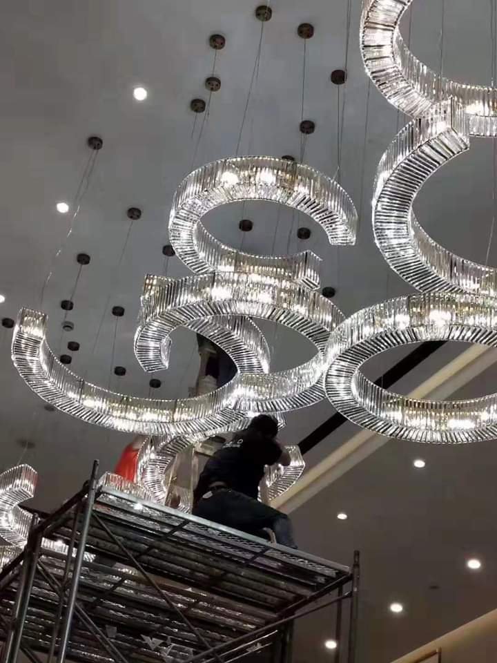 16-foot crystal script chandelier being installed at The Sapphire Estate Indore