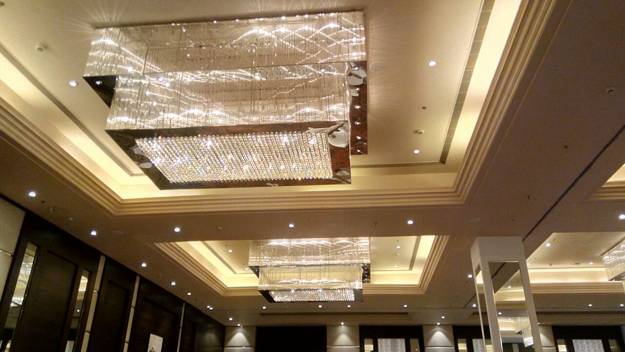 Multiple square crystal chandeliers repeated through a Dehradun banquet hall
