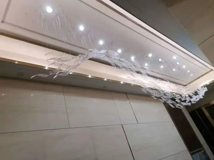 Long corridor chandelier with suspended frosted and clear glass elements at Chateau Royale Hotel and Banquet Nagpur