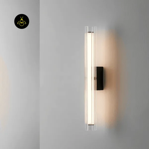 Lit fluted glass wall lamp on a grey wall, warm 3000K glow spreading around the matte black mount