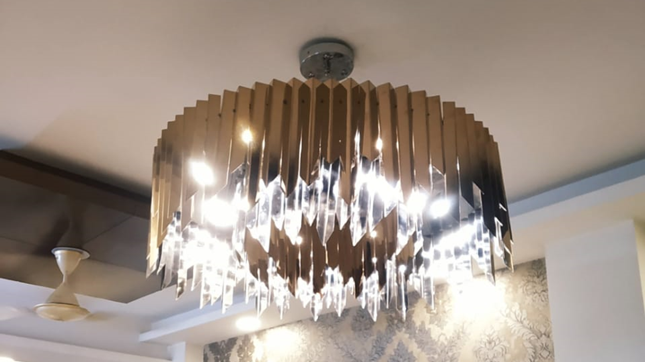 Round residential chandelier with metallic fins and crystal drops installed in a Delhi flat