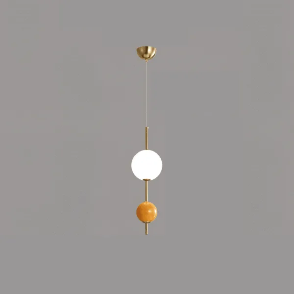 Glass ball pendant light, opal globe and orange ball on a slim gold stem with dome canopy, against a grey background