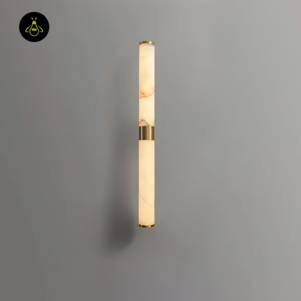 Alabaster wall light mounted upright on a grey wall, the stone glowing warm through its veins