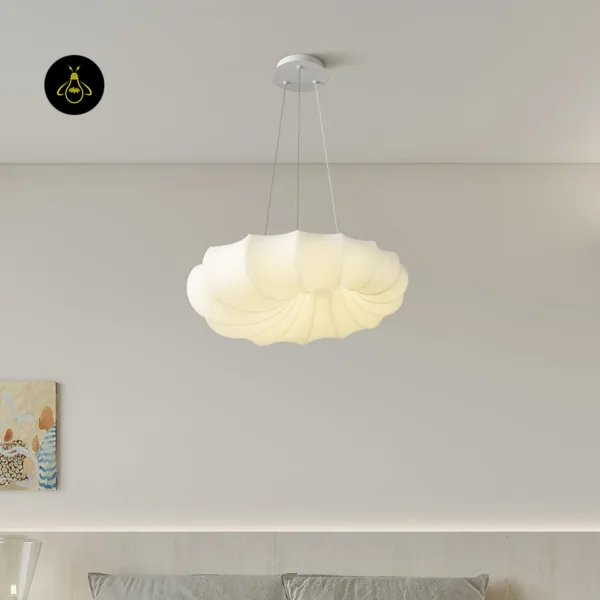 Cloud hanging light lit over a pale grey room with a sofa below and art on the wall