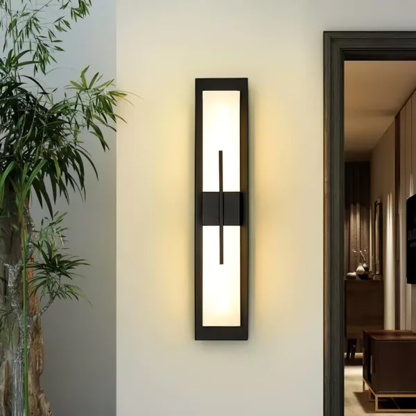 Alabaster outdoor wall light mounted vertically beside a doorway with a bamboo plant