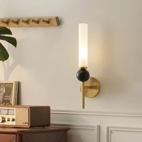 Marble wall sconce above a wooden console with a vintage radio and books in a living room