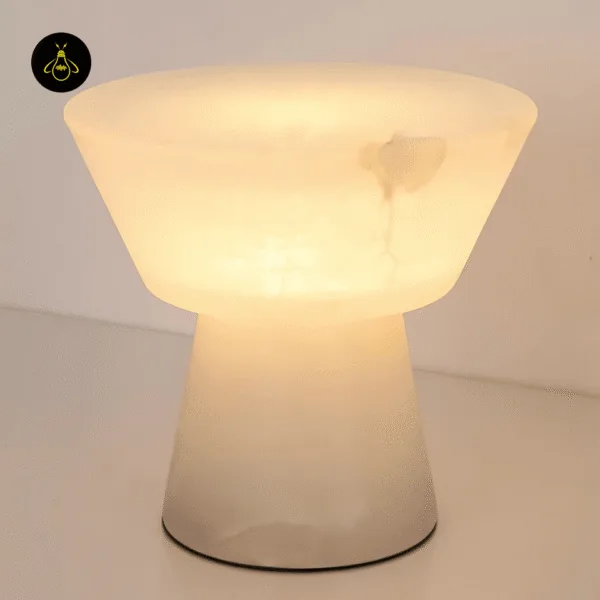 Alabaster mushroom table lamp lit, warm honey glow through the stone bowl