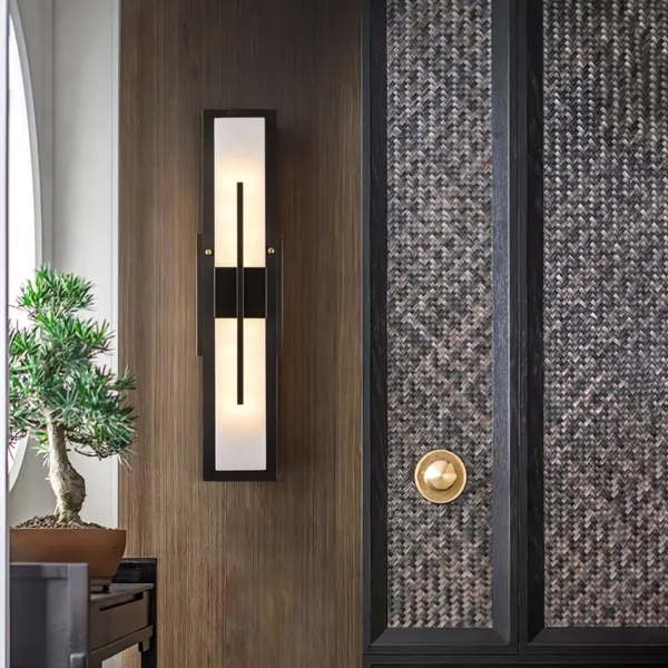 Alabaster outdoor wall light on a wood-panelled entrance wall beside a woven door and bonsai