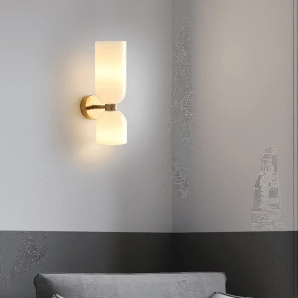 Opal glass wall sconce for bedroom casting warm up and down light on a grey wall above a sofa