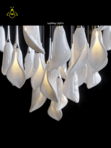 Close-up of warm-lit white glass leaf pendants on the modern jhumar hall chandelier