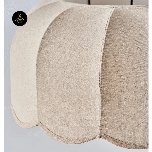 Close-up of the unlit fabric pendant light: beige linen panels, piped seams and scalloped edge