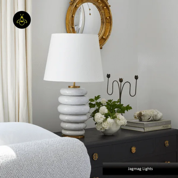 Stacked ceramic table lamp on a bedroom nightstand giving warm ambient light
