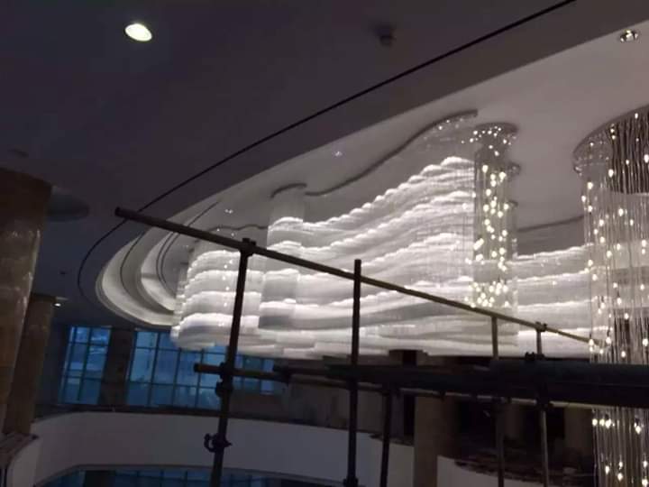 Wide installation-stage view of the Luxe Cascade wave chandelier system in Pune