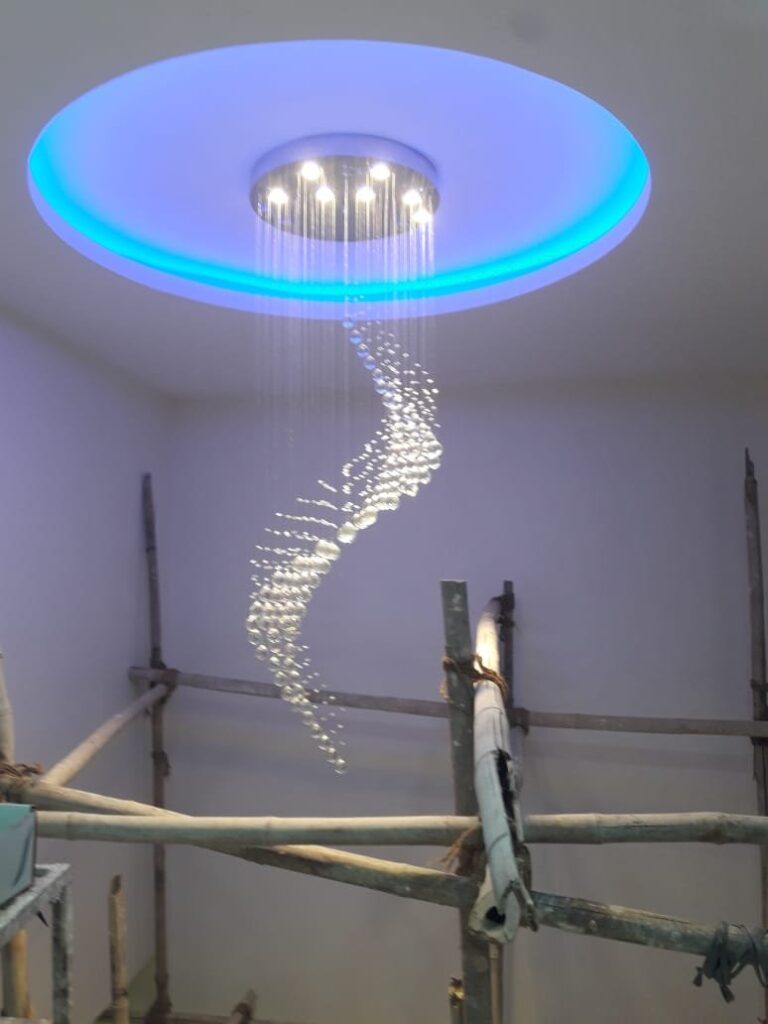Twisting rain-drop crystal chandelier installed in a Ranchi residential double-height space