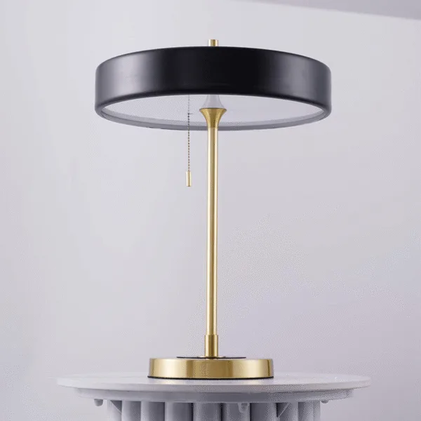 Round gold base of the retro study lamp with its matte black metal disc shade
