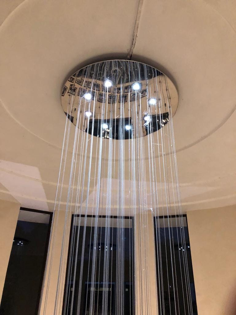 School Chandelier Siliguri: DPS Radiance's 12-Foot Globe Cascade 5 Tall cluster of glowing glass globes suspended through the DPS Siliguri interior