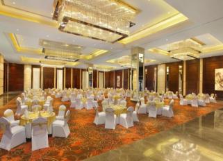 Sarovar Portico Dehradun banquet hall set for an event under crystal ceiling chandeliers