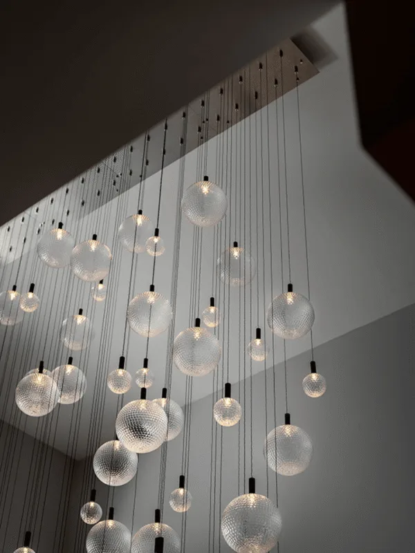 Satin-steel glass sphere chandelier in a contemporary high-ceiling setting