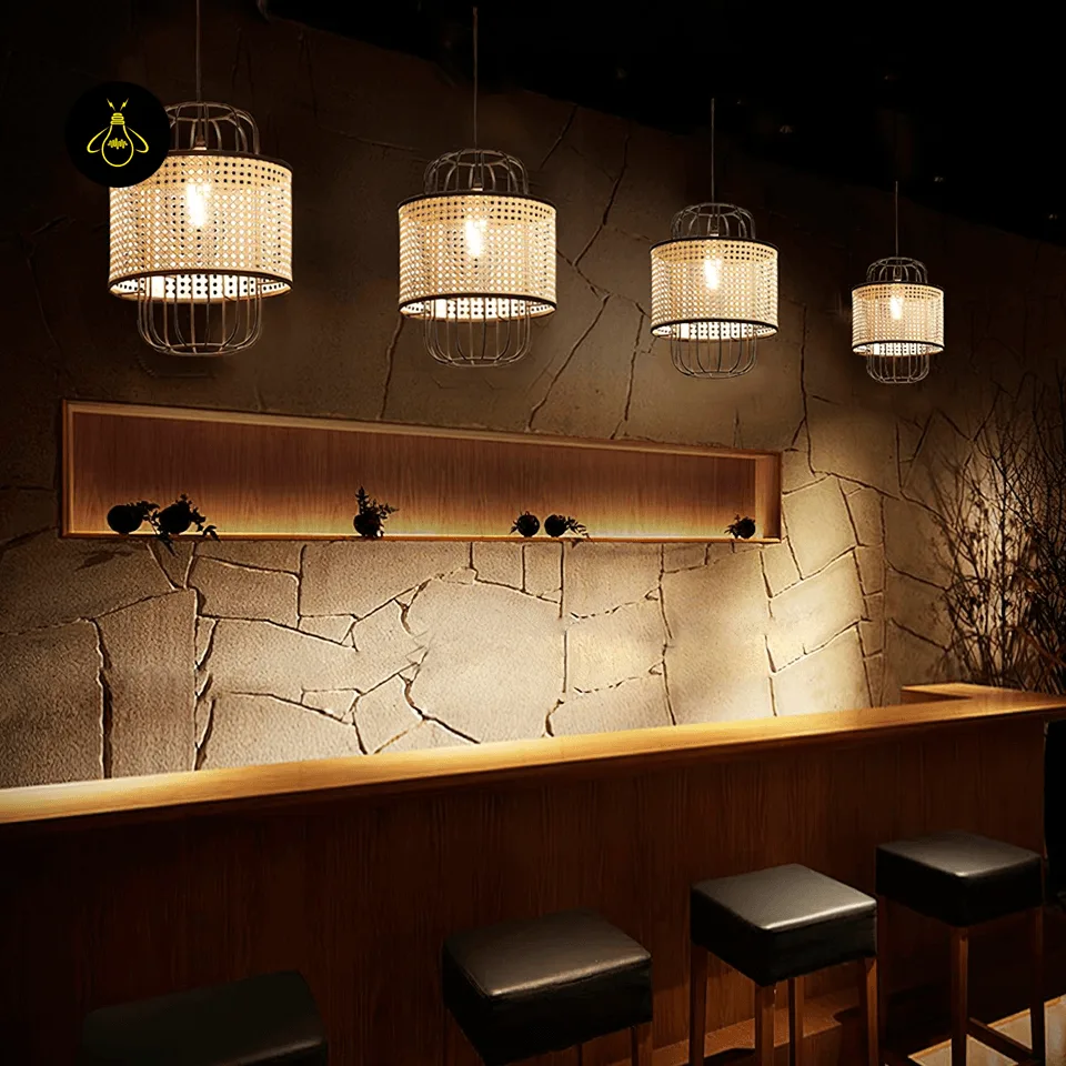 Woven Rattan Pendant Light – Black Cage Lantern, 40 cm 6 Woven rattan pendant lights in a row casting warm cane shadow patterns over a bar counter