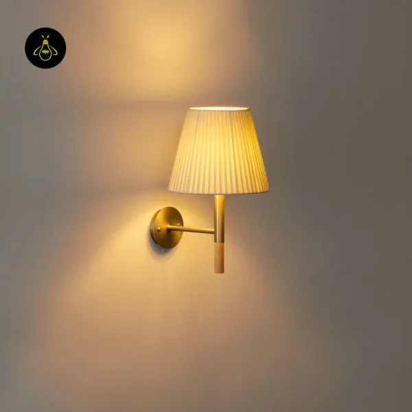 Fabric wall light glowing up and down on a wall, pleated silk shade with a natural wood accent below