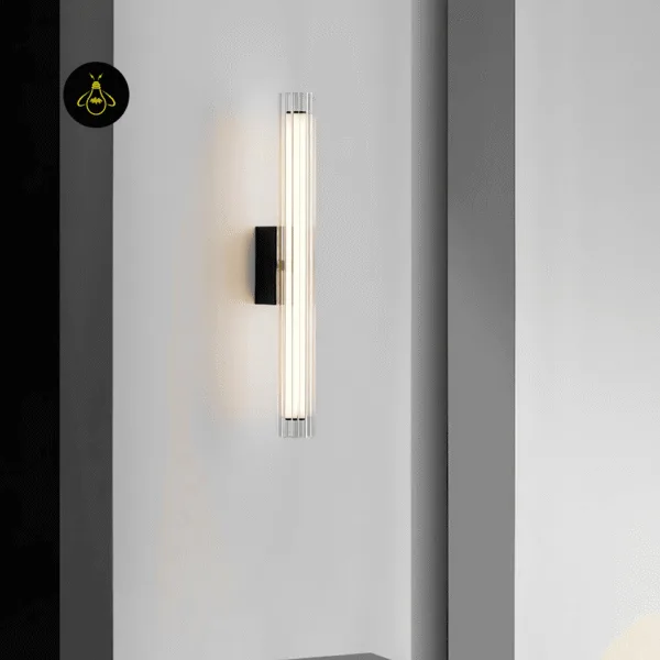 Fluted glass wall lamp lighting a white hallway wall with a matte black backplate