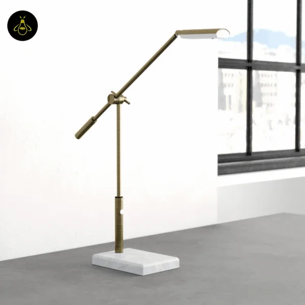 Antique brass marble desk lamp with adjustable balance arm beside a window