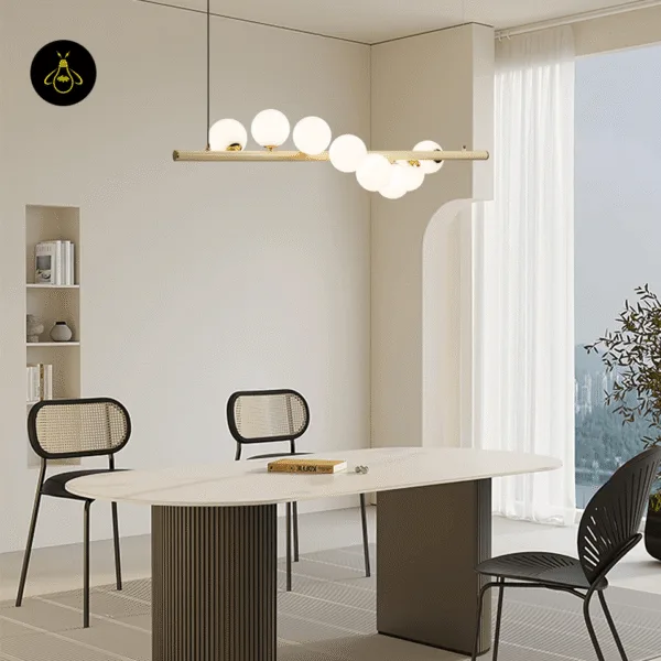 Linear glass ball chandelier casting a soft warm glow over a dining table