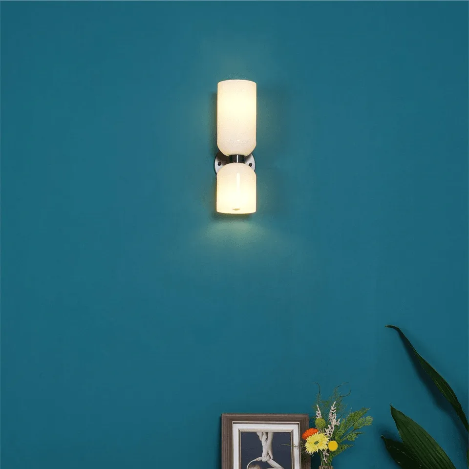 Up Down Wall Light – Opal Glass Wall Sconce, Satin Brass Finish, 35 cm 10 Lit wall sconce for bedroom with opal borosilicate glass shades on a teal wall above a picture frame