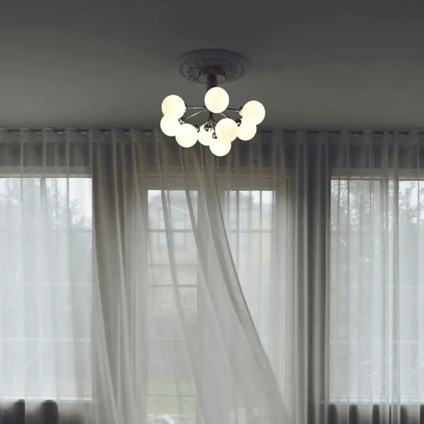 Glass globe cluster chandelier installed in a modern living room near sheer curtains
