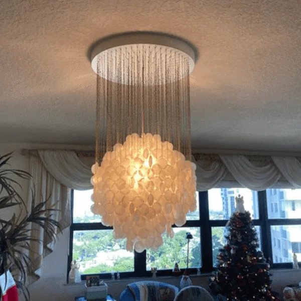 Lit capiz shell chandelier casting a warm glow in a living room