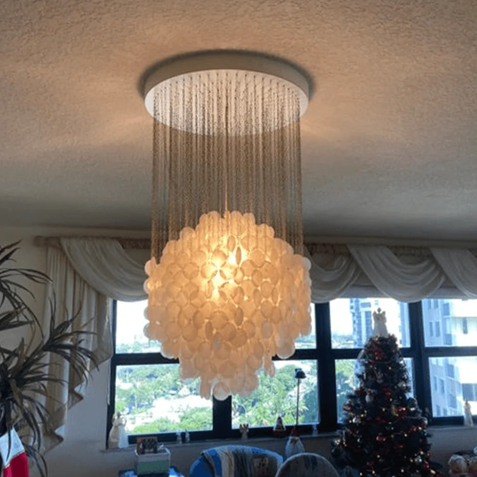 Capiz Shell Chandelier – 80 cm White Cascade of Iridescent Shells 7 Lit capiz shell chandelier casting a warm glow in a living room