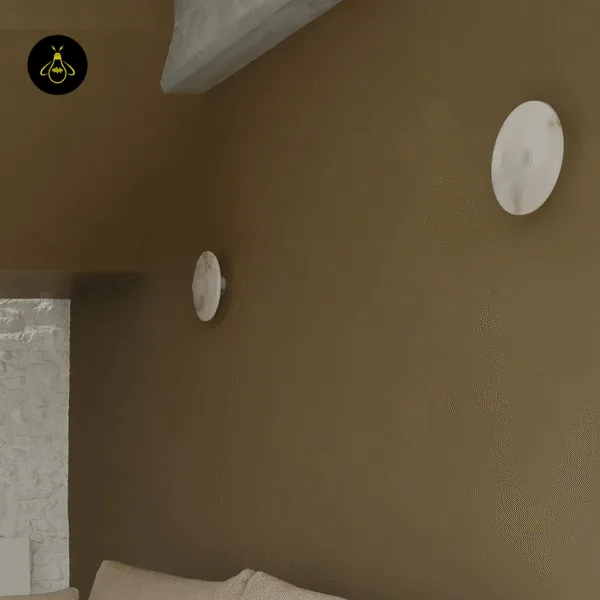 Two alabaster disc wall lights on a brown bedroom wall, one seen from the side to show the slim profile